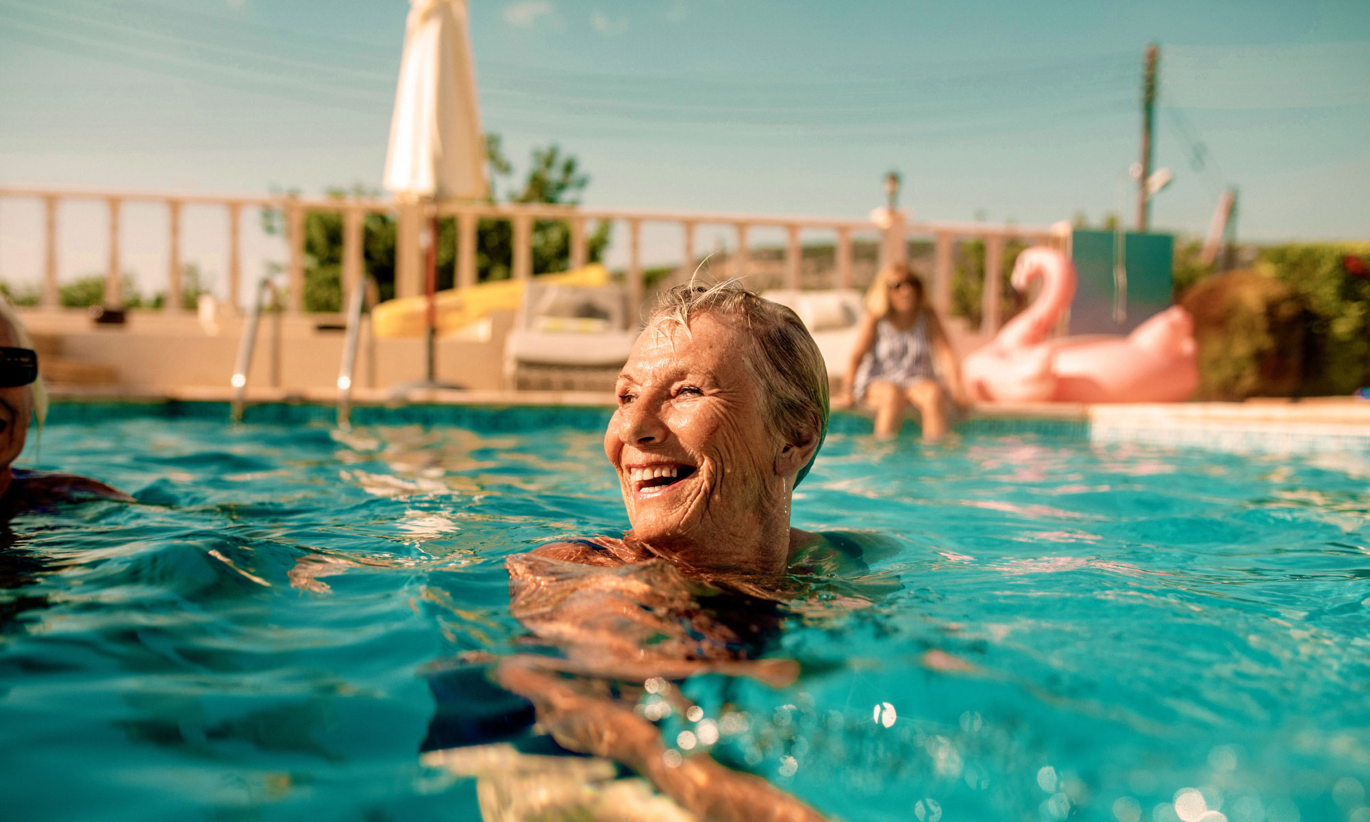Senior woman laughing and swimming in the pool