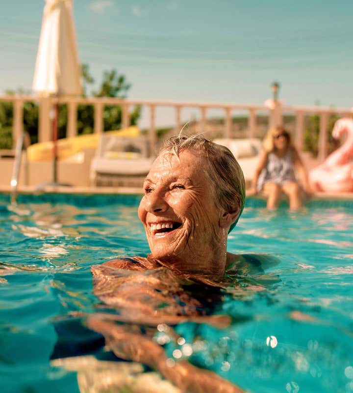 Senior woman laughing and swimming in the pool