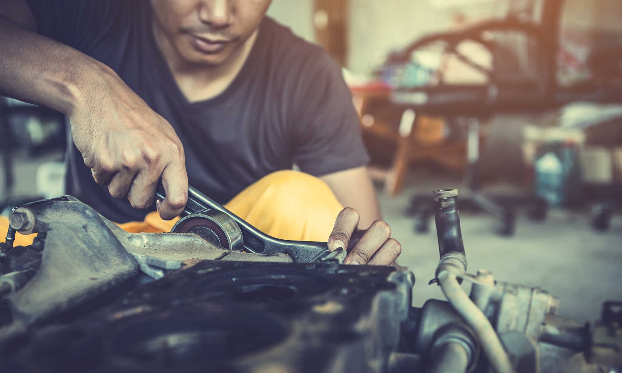 Mechanic using wrench and maintaining an engine