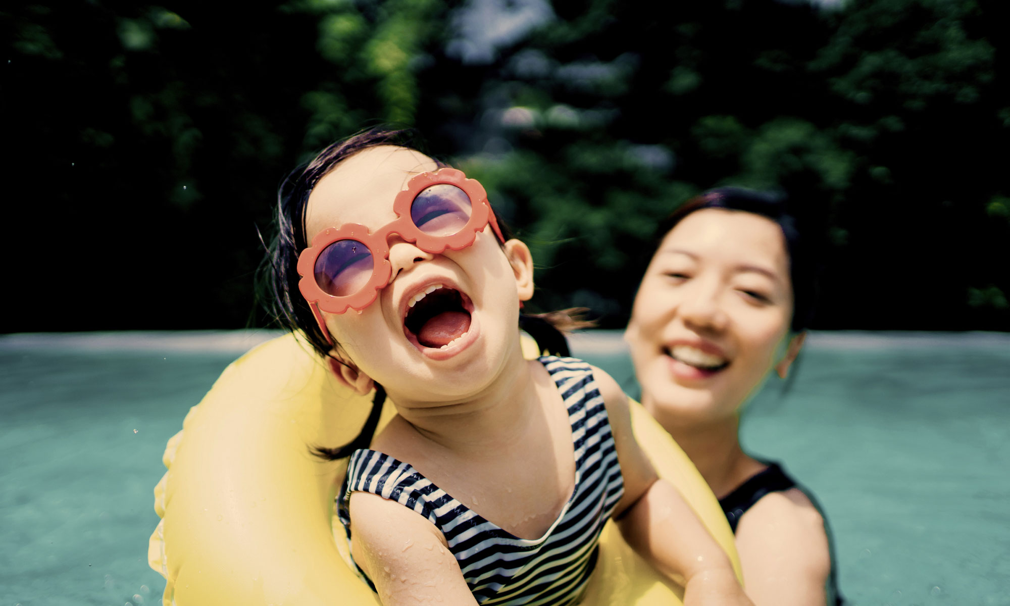 Woman playing with her daughter in a pool
