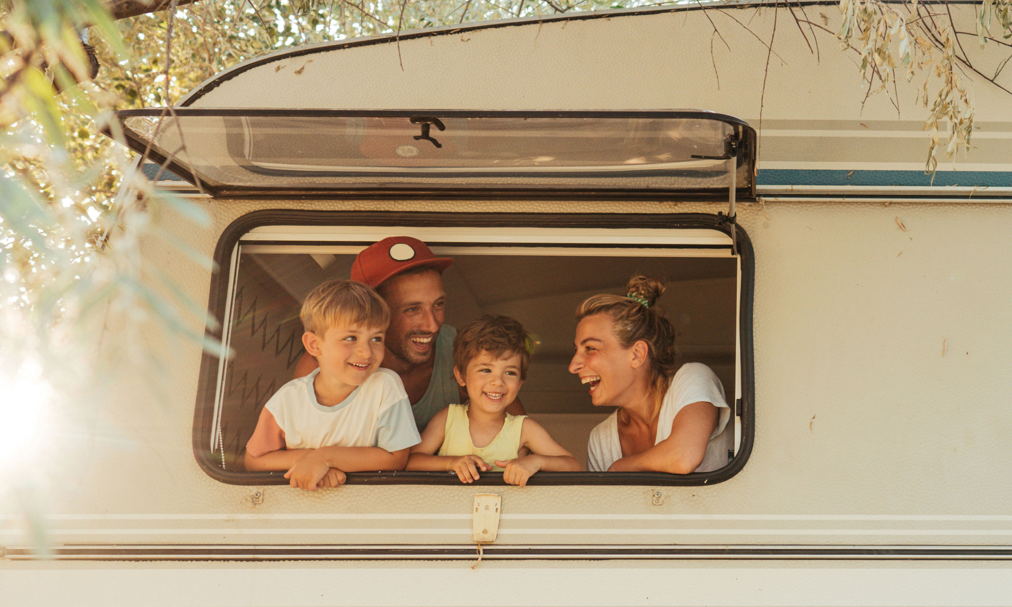 Family looking out of the window of a caravan