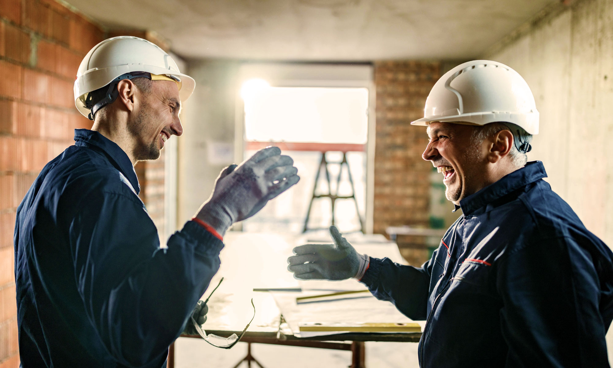 Builders laughing and shaking hands