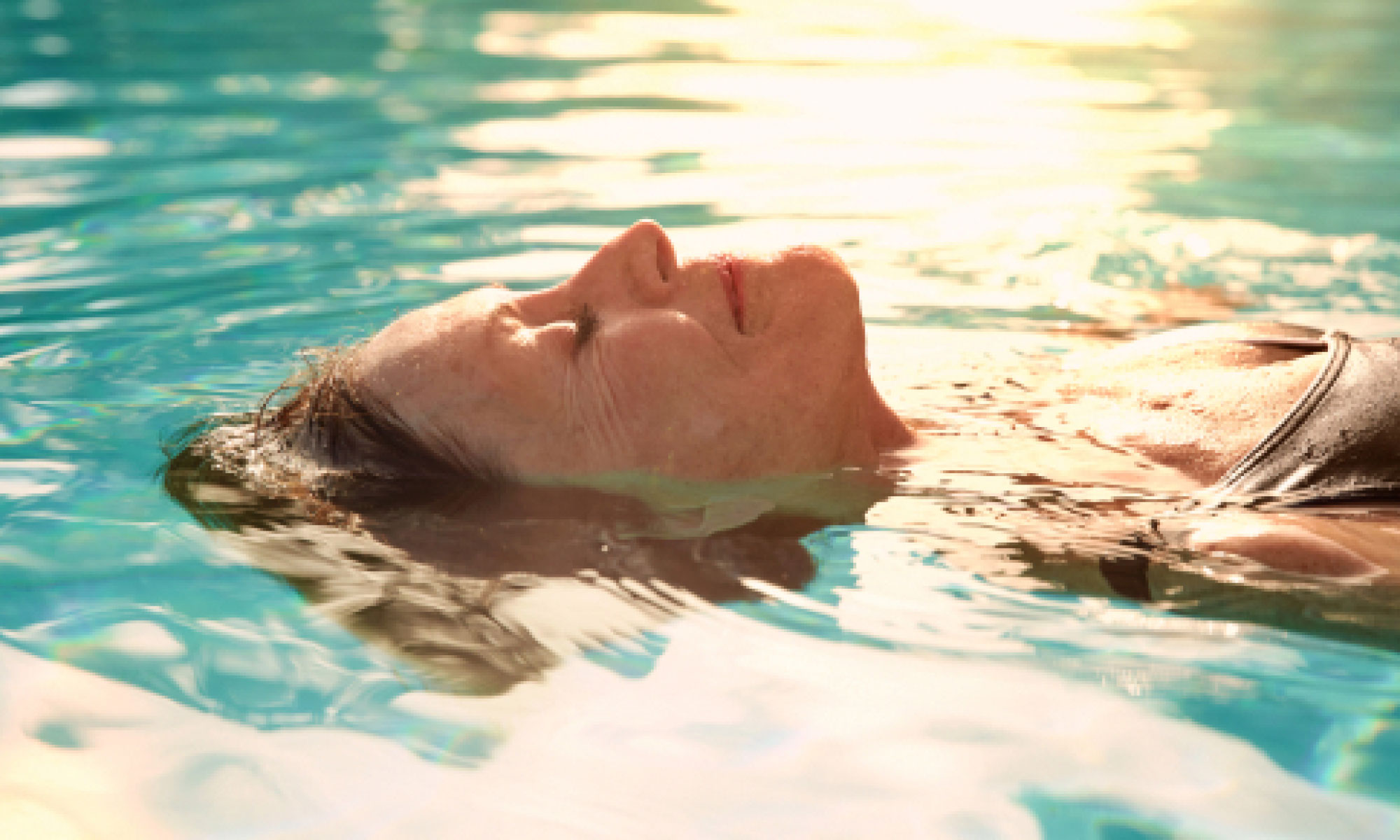 woman swimming in a pool with her eyes closed