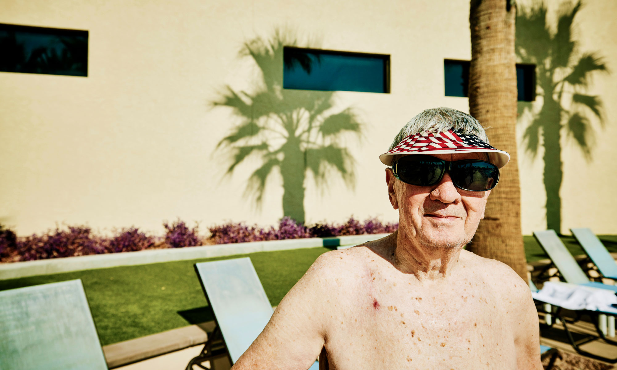 Senior man sunbathing while searing sunglasses