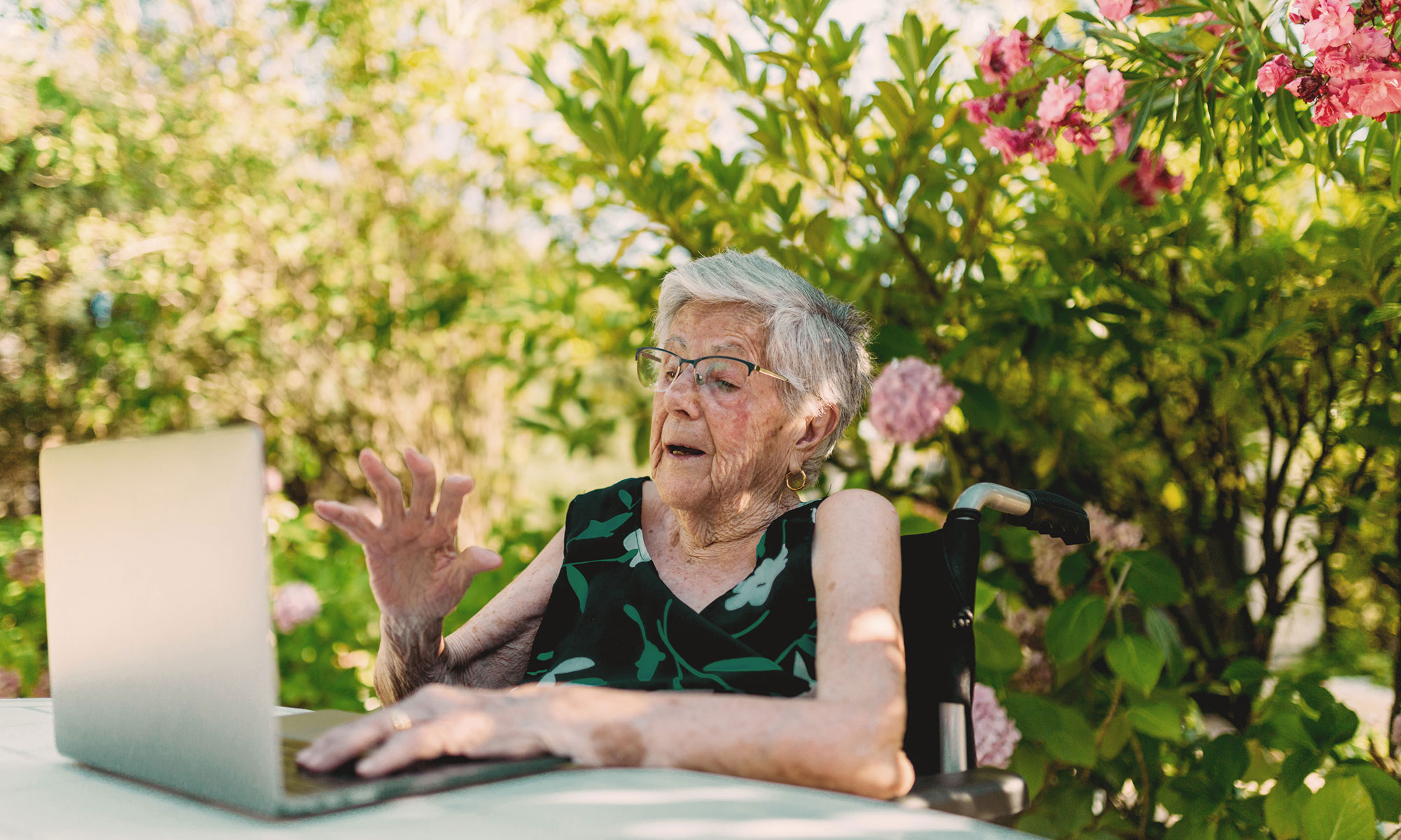 Senior woman looking at deal on her laptop in her garden