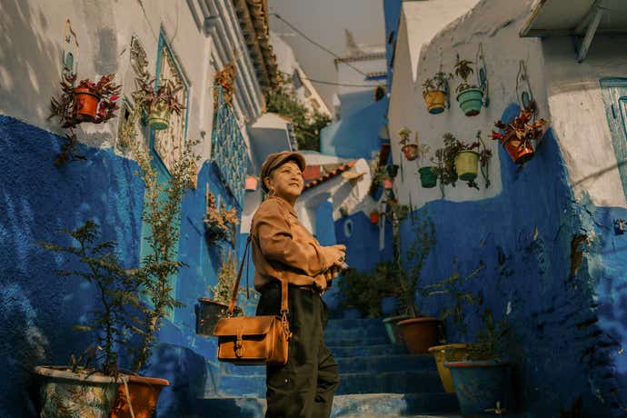 woman posing in the streets of blue and white buildings