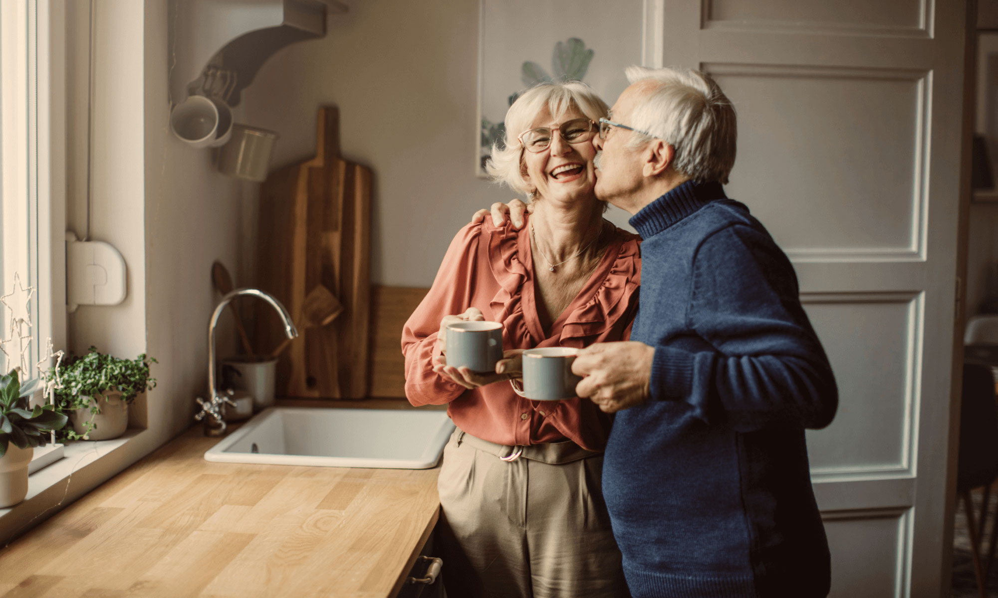 Senior couple enjoying a hot drink in their kitchen